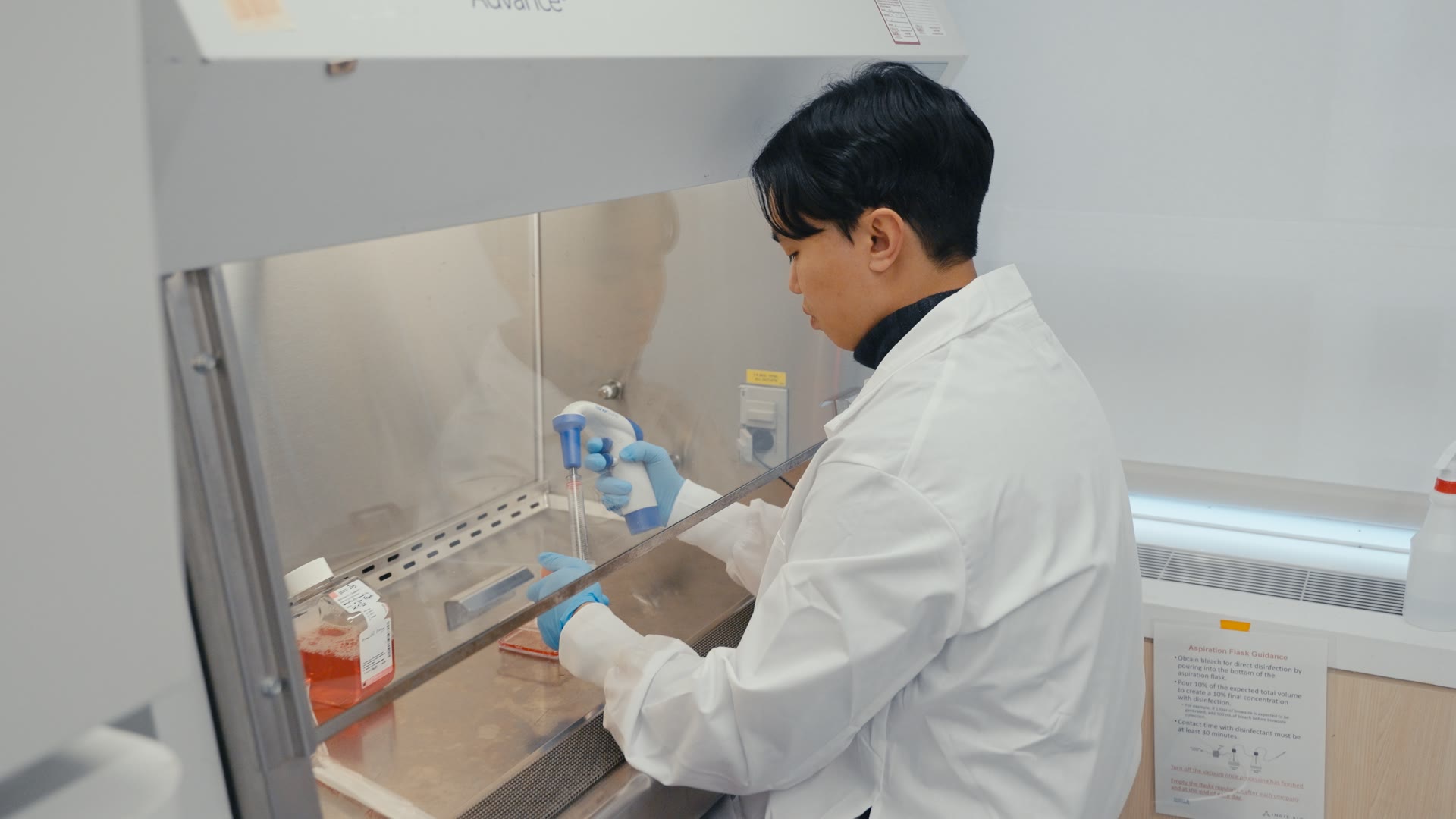 Klona scientist pipetting samples in a biosafety cabinet